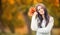 Young attractive woman with bouquet autumn leaves in hand. Fall