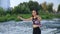 Young attractive woman with braided hairstyle jumping rope against the background of the river