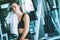 Young attractive woman caucasian sitting and using towel to wipe the sweat. Relaxation after hard workout in gym.