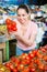 Young attractive woman choosing tomatoes in greengrocery