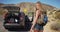 Young attractive woman comes across abandoned vehicle in the desert