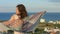 Young attractive woman dancing with scarf, enjoying vacation at seaside resort