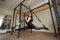 Young attractive woman does splits crossfit stretching with trx fitness straps in the gym& x27;s studio.