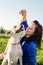 Young attractive woman feeding her dog in the park in summer day