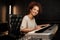 Young attractive woman happily looking in camera playing on electric piano in recording studio. Female musician working