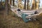 Young attractive woman laying in the hammock in sunny forest, resting after active hike - photo with selective focus