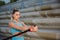 Young attractive woman makes fitness workouts on the promenade