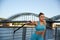 Young attractive woman makes fitness workouts on the promenade