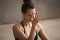 Young attractive woman making nadi shodhana pranayama, grey stud