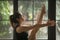 Young attractive woman in Paripurna Navasana pose, window backgr