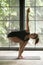 Young attractive woman in Parivrtta Utkatasana pose, studio back