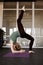 A young attractive woman performs a handstand. The girl is engaged in yoga from a modern Studio