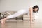 Young attractive woman in Plank pose at cozy living room