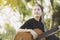 Young attractive woman playing acoustic guitar