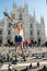 Young attractive woman posing with pigeon near Milan Cathedral, Italy