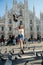 Young attractive woman posing with pigeon near Milan Cathedral, Italy