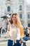 Young attractive woman posing with pigeon near Milan Cathedral, Italy