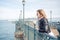 Young attractive woman with reflective expression standing on bridge