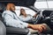 Young attractive woman salesperson in car showroom showing a car to her male client