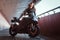 Young attractive woman is standing in tunnel with her bike and helmet