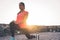 Young attractive woman stretching next the beach during a magnificent sunset - Sporty health girl workout outdoor