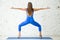 Young attractive woman in Sumo Squat pose, white studio backgrou