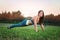 Young attractive woman training in the park. Exercise plank. Fit