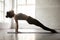 Young attractive woman in Upward Plank pose, white studio backgr