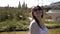 Young attractive woman is walking in the park on a green lawn and smiling - nature with modern buildings