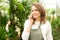 Young attractive woman working at the plants nursery using smart