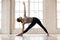 Young attractive yogi woman practicing yoga in Utthita Trikonasa