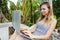 Young aucasian woman chatting by laptop on exotic resort, wearing grey shirt.