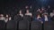 Young audience wearing face masks enjoying time in cinema.