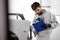 Young auto mechanic male conducts diagnostics of car body before its renovation