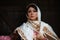 Young azeri woman in traditional Azerbaijani dress standing at the wooden door