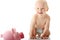 Young baby boy playing with pink piggy bank