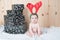 Young baby wearing a santa claus suit and hat in christmas in a barn