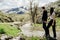 Young backpacker hiker couple enjoying relaxing mountain hike.Active hiking trip vacation.Walking by the mountain stream.Climbers