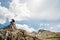 Young backpacker hiker man enjoying adrenaline mountain hike.Active hiking trip vacation.Climbing to the top of mountain cliff.