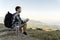 Young backpacker sitting on mountains valley drink tea feel calm