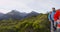 Young Backpackers Walking On Boardwalk Amidst Trees At Routeburn Track