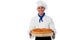 Young baker holds a loaf on breadboard