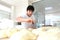 A young Baker puts a portion of dough on the table. Hands and dough are out of focus. Yeast dough in the hands of a Baker. The