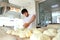 A young Baker puts a portion of dough on the table. Hands and dough are out of focus. Yeast dough in the hands of a Baker. The