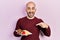 Young bald man eating fresh and healthy fruits smiling happy pointing with hand and finger