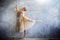 Young ballerina in a golden colored dancing costume is posing in a loft studio