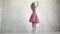 A young ballerina in a pink classic pack and pointe shoes gracefully dances. beauty and grace of ballet