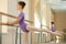 Young ballerina practice on barre.