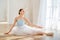 A young ballerina is rehearsing in the studio. happy young ballerina exercising in the barre. Young pretty ballet dancer