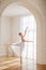 A young ballerina is rehearsing in the studio. happy young ballerina exercising in the barre. Young pretty ballet dancer